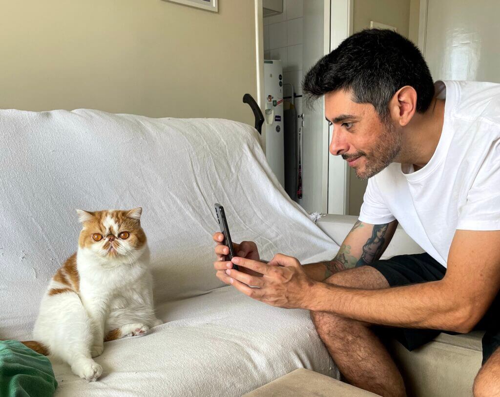Cat sitter em São Paulo interagindo e registrando foto de gato durante visita domiciliar