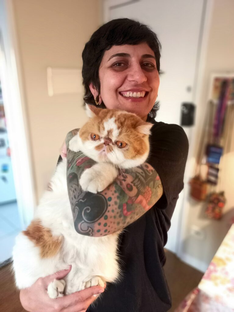 Cat sitter realizando atendimento domiciliar em apartamento de São Paulo com gato no colo durante visita.